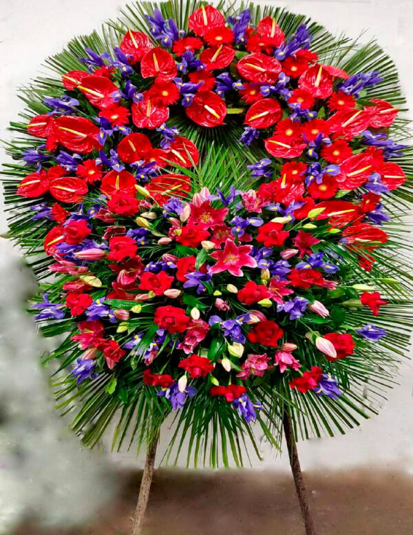 Corona_di_Anthurium_Rossi_Iris_Blu_e_Gerbere_Rosse_con_Ciuffo_di_Lilium_Rosa_e_Rose_Rosse